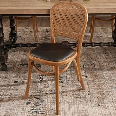 a wooden table with chairs and a rug on the floor