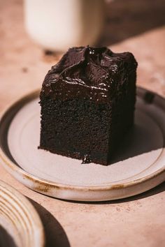 a piece of chocolate cake sitting on top of a white plate