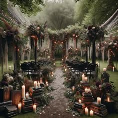 an outdoor ceremony setup with candles and flowers on the aisle, surrounded by greenery