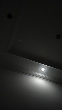 a light that is on in the dark with some lights shining down from it's ceiling