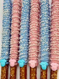 four pink, blue and white dessert sticks with sprinkles