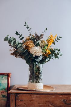 a vase filled with flowers sitting on top of a wooden table