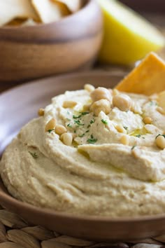 a bowl filled with hummus and cheese on top of a table