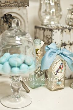 a glass jar filled with blue candies on top of a table next to other items