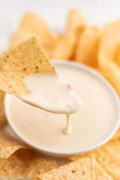 a tortilla chip being dipped with ranch dip