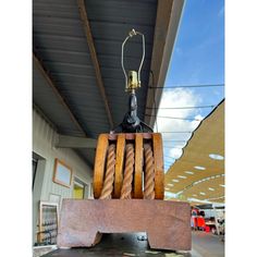 a wooden chair sitting on top of a metal table in front of a building with a light bulb attached to it