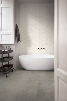 a white bath tub sitting inside of a bathroom next to a wall mounted shower head