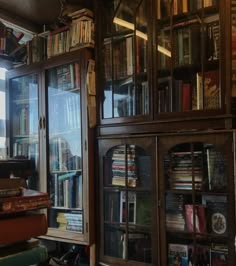 a bookshelf filled with lots of books next to a window