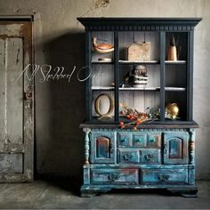 an old blue china cabinet with glass doors