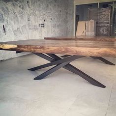 a large wooden table sitting on top of a white tile floor next to a wall