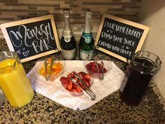 a table topped with drinks and fruit next to two chalkboards that say menus bar