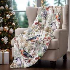 a christmas tree is next to a chair with a blanket on it