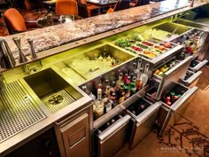 an open bar with lots of bottles and glasses on it's counter top in a restaurant