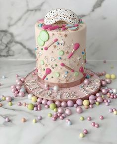 there is a pink cake with sprinkles on it