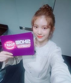 a woman holding up a purple box with the word show on it