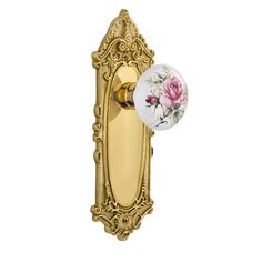 an ornate brass door handle with pink roses on the front and side panel, is shown