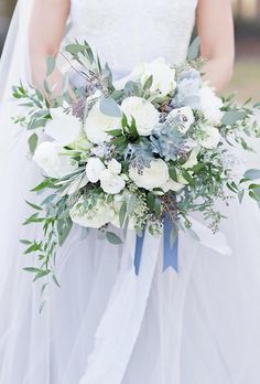 a bridal holding a bouquet of white and blue flowers