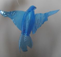 a blue glass bird ornament hanging from a hook with the words from bottle to bird on it