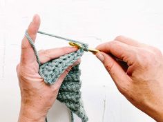 two hands crocheting the ends of a piece of yarn