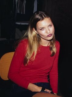 a woman sitting in a chair with her hands on her hips