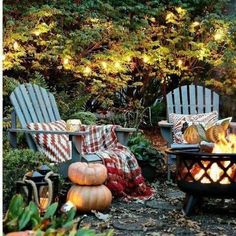 an outdoor fire pit surrounded by lawn chairs and pumpkins in the fall time garden