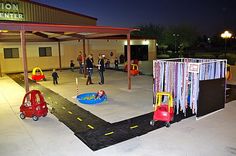 an outdoor play area at night with children playing on the ground and people walking around