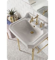 a white sink sitting next to a mirror on top of a tiled floor in a bathroom