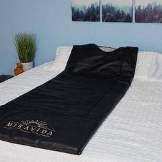 a bed with a black blanket on top of it