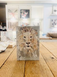 a glass block with a painting of a lion on it sitting on a wooden table