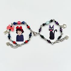 two bracelets with cartoon characters on them, one has a cat and the other has a dog