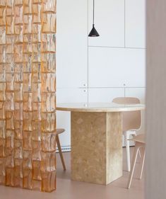 a room with a table, chairs and a wall made out of glass blocks in it