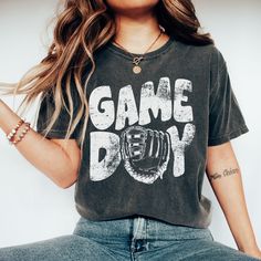 a woman wearing a game day t - shirt and jeans