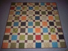 a multicolored patchwork quilt on the floor