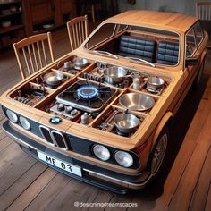 an old bmw is sitting on the floor in front of a table with bowls and pans