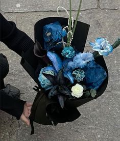 a person holding a bouquet of blue flowers