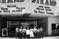 a group of people standing in front of a theater