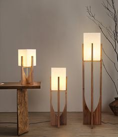 three wooden lamps sitting next to each other on a table