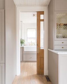 an open door leading to a bathroom with white fixtures