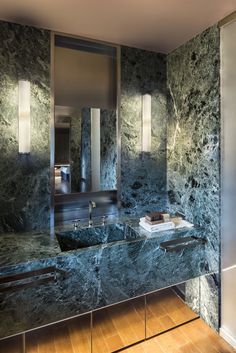 a bathroom with marble counter tops and mirrors