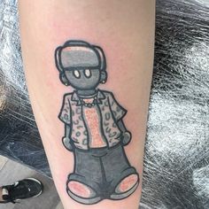 a person has a tattoo on their leg with a drawing of a man wearing headphones