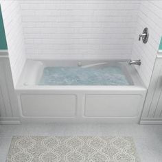 a bathroom with a bathtub and rug on the floor