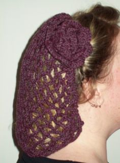 a woman wearing a purple crocheted hat with a flower on it's side