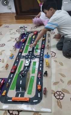 two children playing with toy cars on the floor