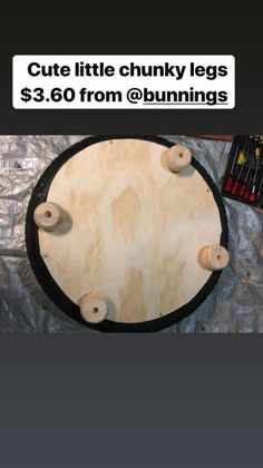 a round wooden table sitting on top of a pile of wood