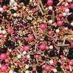 pink, white and black sprinkles are scattered on top of each other