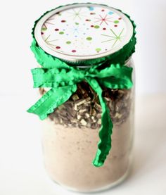 a jar filled with oatmeal sitting on top of a white table next to a green ribbon