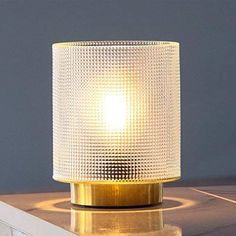 a white lamp sitting on top of a wooden table