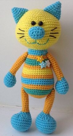 a crocheted yellow and blue cat stuffed animal