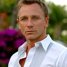 a close up of a person wearing a white shirt and suspenders with blue eyes