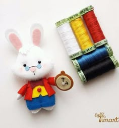 a small stuffed animal next to some spools of thread